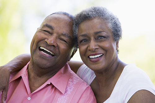 African american couple sitting outside smiling and laughing together